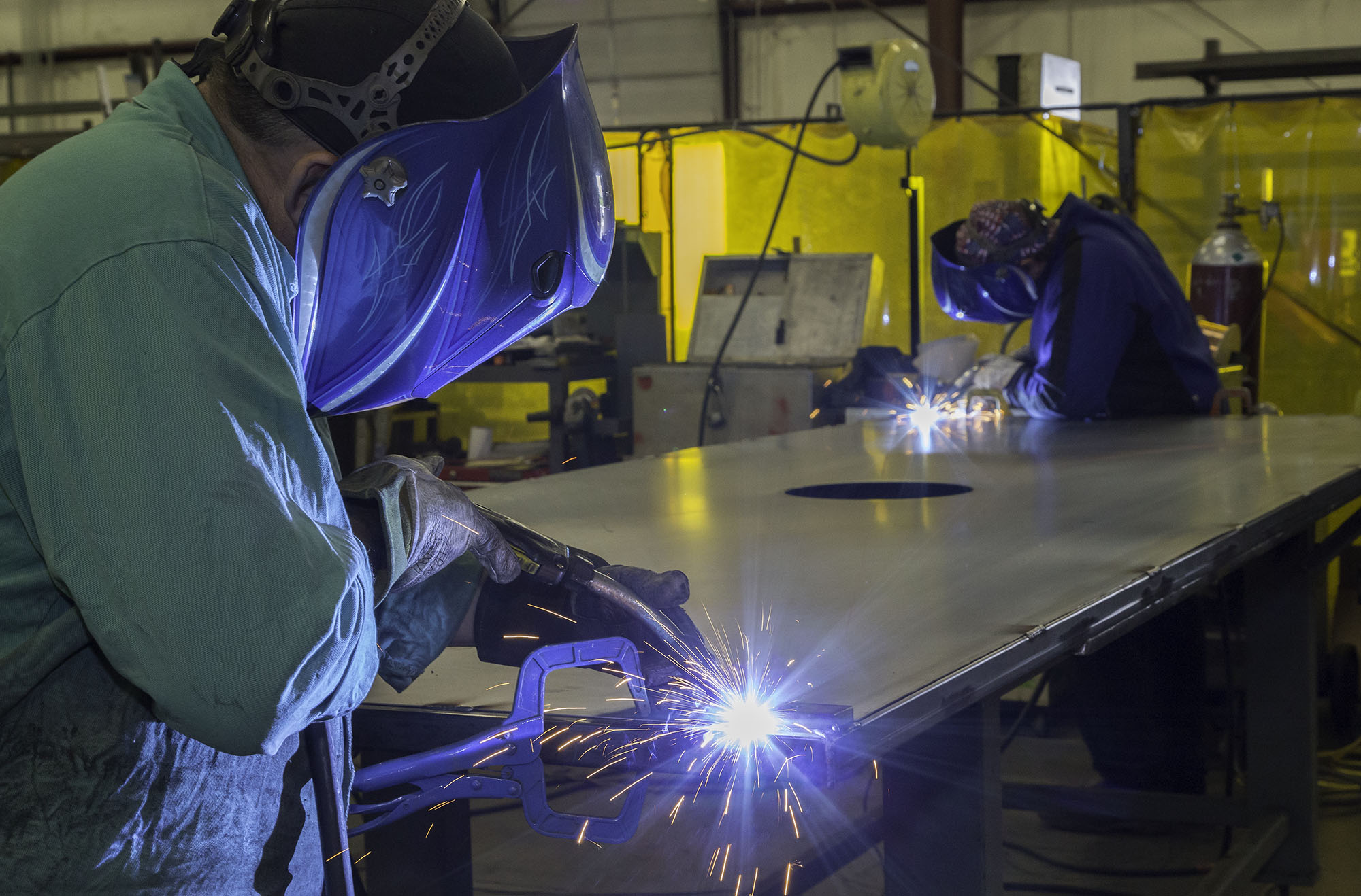 welders at a robotics fabrication facility