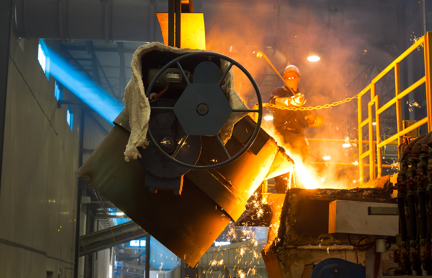 worker preparing molten iron for molds