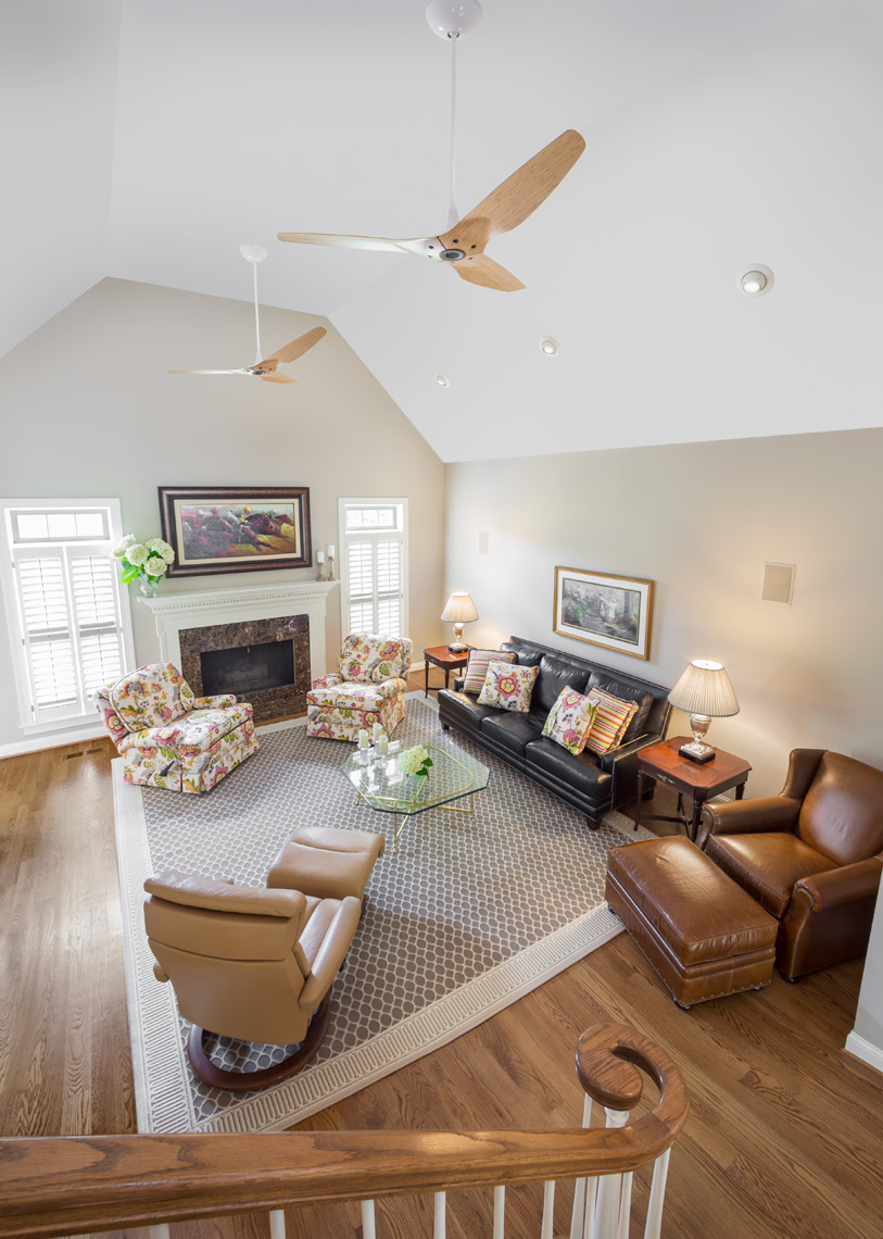 traditional open living room with ceiling fans