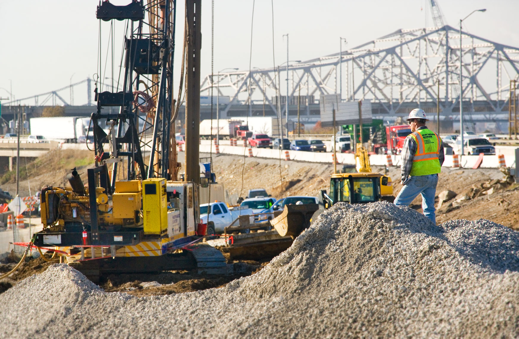 Construction worker supervising pile boring for bridges