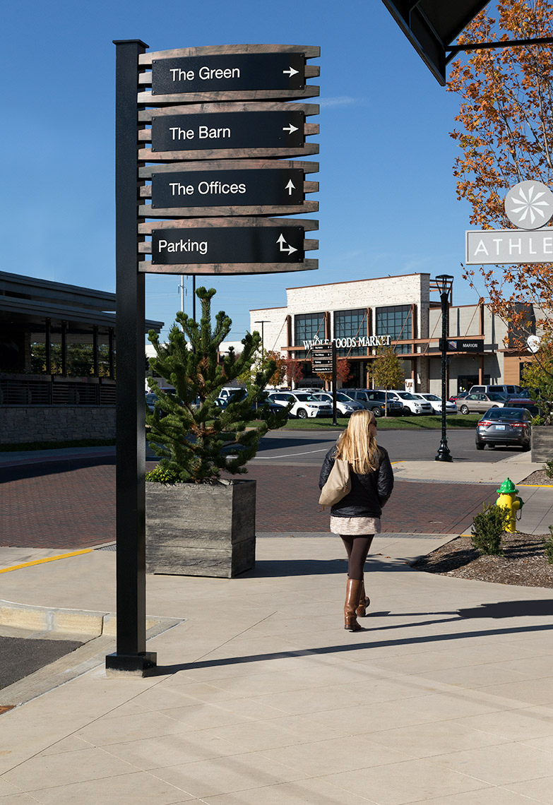 Vehicular directional sign at summit with "whole foods"